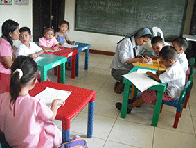 Sr Perpetua teaching children in a Parish School in Buhol