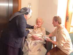 r Albert distributing Holy Communion to an old lady in an Old People's Home